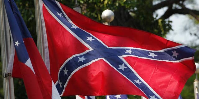 FILE - In this July 19, 2011 file photo, Confederate battle flags fly outside the museum at the Confederate Memorial Park in Mountain Creek, Ala., Tuesday, July 19, 2011. Major retailers are halting sales of the Confederate flag after the June 17, 2015 shooting deaths of nine black church members in South Carolina. (AP Photo/Dave Martin, File)