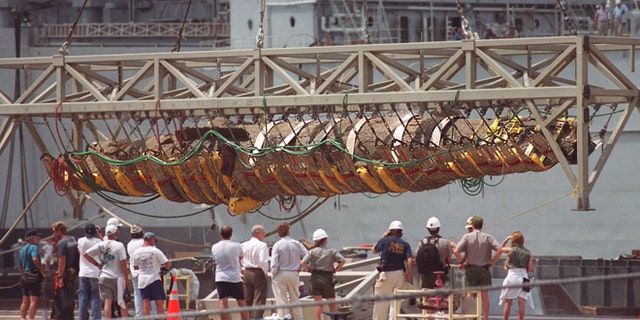 The Confederate submarine H.L. Hunley is raised from a barge by a crane at the former Charleston Naval Base in North Charleston, S.C., in this Aug. 8, 2000, file photo.