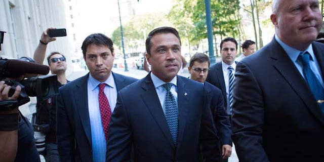 Former U.S. Rep. Michael Grimm, center, arrives ahead of his sentencing at federal court Friday, July 17, 2015, in the Brooklyn borough of New York. Grimm pleaded guilty late last year to aiding in filing a false tax return, a charge that stemmed from an investigation into the Staten Island Republican's campaign financing. (AP Photo/Kevin Hagen)
