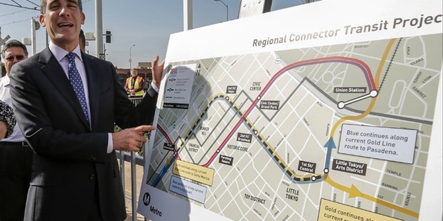 Los Angeles Mayor Eric Garcetti looks at the proposed "Regional Connector Transit Project" plan as he attends a federal grant signing ceremony in Los Angeles Thursday, Feb. 20, 2014. The light rail public transit system in Los Angeles is getting $670 million to solve one of its most vexing design deficiencies: Train riders who want to travel from one side of downtown and out the other must transfer twice. The "regional connector," as the Los Angeles County Metropolitan Transportation Authority calls it, will tie together three existing light rail lines with a new tunnel and three new stations. Major construction should begin later this year, with a cost estimated of $1.4 billion, to be opened in 2020. (AP Photo/Damian Dovarganes)