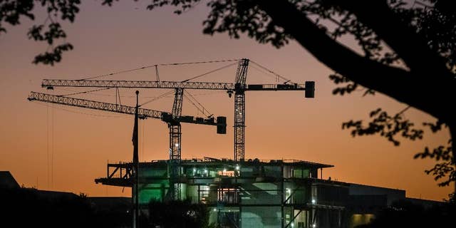 In this Oct. 8, 2014 photo, construction cranes are silhouetted against the early morning sky as work continues on Smithsonian's new National Museum of African American History and Culture in Washington. The Commerce Department releases construction spending for September on Monday, Nov. 3, 2014. (AP Photo/J. David Ake)