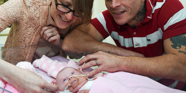 Naomi Findlay and Dean Wilkins, look at their daughter, three-week-old Vanellope Hope Wilkins who was born with an extremely rare condition in which the heart grows on the outside of the body, at Glenfield Hospital in Leicester.