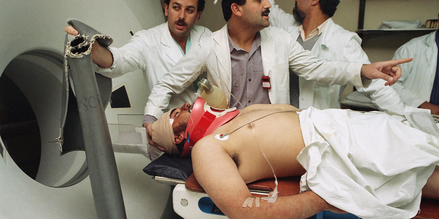 FILE - In this Feb. 26, 1994 file photo, a Palestinian resident of the West Bank town of Yatta, who was shot in the head and critically wounded by Israeli troops during clashes, is taken out of a CAT scan machine at East Jerusalem's Makassed Hospital. Bassem Abu Libdeh, the director of Makassed Hospital said Sunday, Sept. 9, 2018, that a U.S. decision to cut funding to hospitals serving the Palestinians will have a "severe effect." Abu Libdeh said that the U.S. covers 40 percent of costs in six east Jerusalem hospitals that provide care for Palestinians from the Israeli-occupied West Bank and the Gaza Strip. (AP Photo/Jacqueline Arzt, File Photo)