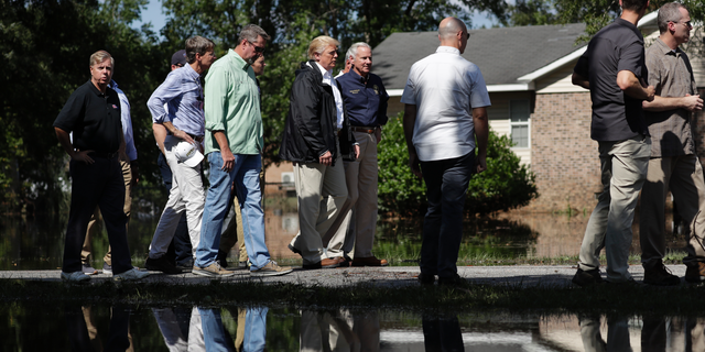 President Donald Trump visits a neighborhood impacted by Hurricane Florence, Wednesday, Sept. 19, 2018, in Conway, S.C. Next to Trump is South Carolina Gov. Henry McMaster. (AP Photo/Evan Vucci)