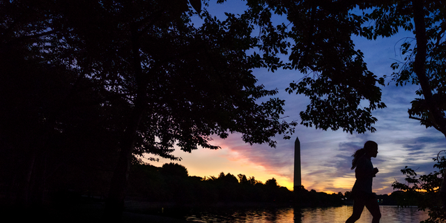 FILE - In this July 25, 2017 file photo, an early morning runner is silhouetted against the rising sun at the Tidal Basin in Washington. Recent killings of women who were attacked while engaged in the sports they love have raised questions about how women can defend themselves and why they must be ready to fight off attackers in the first place. (AP Photo/J. David Ake, File)