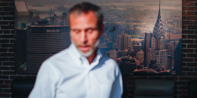 Michael Koveleski, is interviewed in the showroom of their store Design Sleep where an aerial photograph of the Chrysler Building hangs on their wall in Yellow Springs, Ohio on Thursday, Aug. 23, 2018. He and his wife, Margery, left New York in the wake of 9/11 with four children and no work lined up. (AP Photo/John Minchillo)