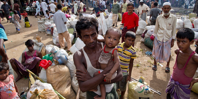 In this Monday, Oct. 2, 2017, file photo, newly arrived Rohingya Muslims from Myanmar prepare to leave a transit shelter in Shahparirdwip, Bangladesh. A team of independent investigators examining alleged violence and killings in Myanmar that caused hundreds of thousands of Rohingya Muslims to flee their homes have issued a searing critique of the United Nations' own operations in the country just as bloodshed erupted in August 2017. (AP Photo/Gemunu Amarasinghe, File)