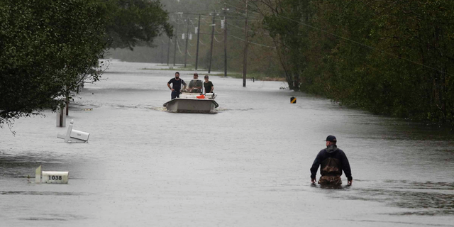 A member of the U.S. Coast Guard walks down Mill Creek Road checking houses after tropical storm Florence hit Newport N.C., Saturday, Sept. 15, 2018. (AP Photo/Tom Copeland)