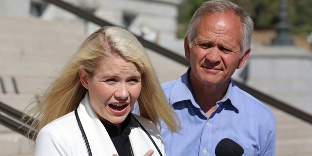 Elizabeth Smart speaks during a news conference while her father Ed Smart looks on Thursday, Sept. 13, 2018, in Salt Lake City. Smart says it appears there is no viable, legal recourse she can take to stop the release of one of her kidnappers. Smart said at a news conference Thursday in Salt Lake City that she only found out about 72-year-old Wanda Barzee's release shortly before the public did. (AP Photo/Rick Bowmer)