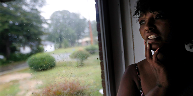 Nichole Worley looks out from her home in Lumberton, N.C., Friday, Sept. 14, 2018, as rains from Hurricane Florence threaten the neighborhood with flooding. Two years ago, Worley’s house, and most of the houses around her, took in water up to its eaves during Hurricane Matthew. “I don’t think we can stand another one,” she says. “I can’t do this again.” (AP Photo/David Goldman)