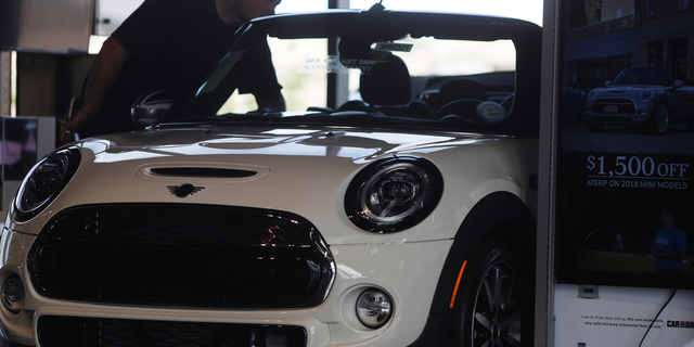 In this Thursday, Aug. 30, 2018, photo, a prospective buyer looks over a 2019 Cooper S convertible on the showroom floor of a Mini dealership in Highlands Ranch, Colo. On Friday, Sept. 14, the Commerce Department releases U.S. retail sales data for August. (AP Photo/David Zalubowski)