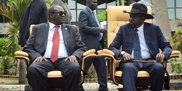 FILE - In this Friday, April 29, 2016 file photo, South Sudan's then First Vice President Riek Machar, left, looks across at President Salva Kiir, right, as the two sit to be photographed following the first meeting of a new transitional coalition government, in the capital Juba, South Sudan. South Sudan's warring parties on Wednesday, Sept. 12, 2018, signed what they say is the final peace agreement to end the country's five-year civil war, which has killed tens of thousands and displaced millions. (AP Photo/Jason Patinkin, File)