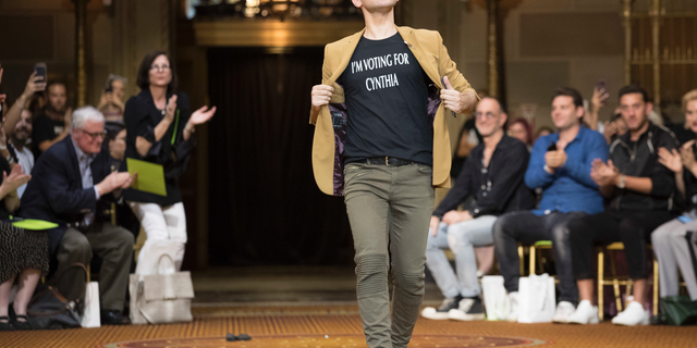 Christian Siriano wears a T-shirt supporting Democratic New York gubernatorial candidate Cynthia Nixon as he walks onto the runway after his spring 2019 collection was modeled during Fashion Week in New York, Saturday, Sept. 8, 2018. (AP Photo/Mary Altaffer)