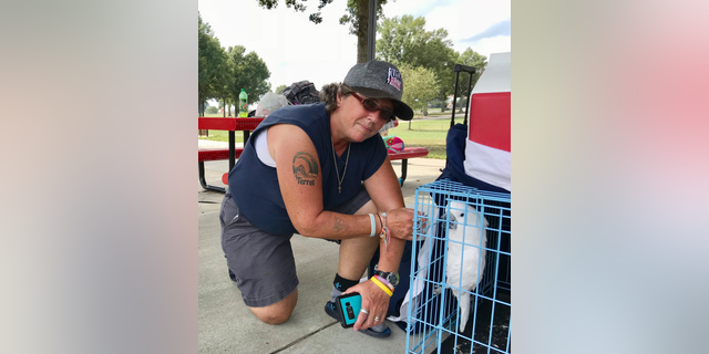 CORRECTS NAME TO LISA, NOT MELODY - Lisa Rawson looks over the possessions she grabbed from her first-floor apartment in Myrtle Beach, S.C., which are now spread out at a campground at the Atlanta Motor Speedway, and her two dogs and a cockatoo Wednesday, Sept. 12, 2018 in Hampton, Ga. She had a tire blow-out in her minivan before arriving around 3 a.m. Wednesday at the speedway, which has invited hurricane evacuees to stay at its vast campgrounds. (AP Photo/Jeff Martin)