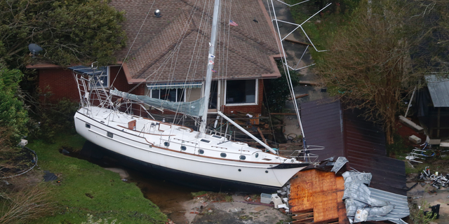 A sailboat is shoved up against a house and a collapsed garage Saturday, Sept. 15, 2018, after heavy wind and rain from Florence, now a tropical storm, blew through New Bern, N.C. (AP Photo/Steve Helber)