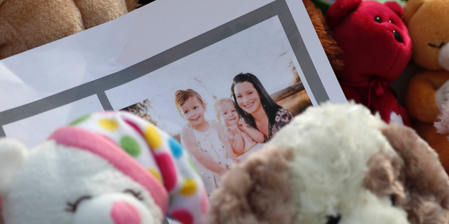 FILE - In this Thursday, Aug. 16, 2018 file photo, a photograph sits amid mementos outside the home where a pregnant woman, Shanann Watts, and her two daughters, Bella and Celeste, lived in Frederick, Colo. Colorado prosecutors want a judge to block release of the autopsy reports of a woman and two young girls found dead at an oil work site, arguing that the cause of their deaths will be "critical evidence" during the trial of the man accused of killing his family. In a request filed in Weld County Court on Monday, Sept. 17, 2018, District Attorney Michael Rourke said releasing information from the autopsies could influence witnesses and affect future jurors. Watts, 33, was arrested and charged in August with murdering his 34-year-old pregnant wife, Shanann, and their two daughters, four-year-old Bella and three-year-old Celeste. (AP Photo/David Zalubowski, File)