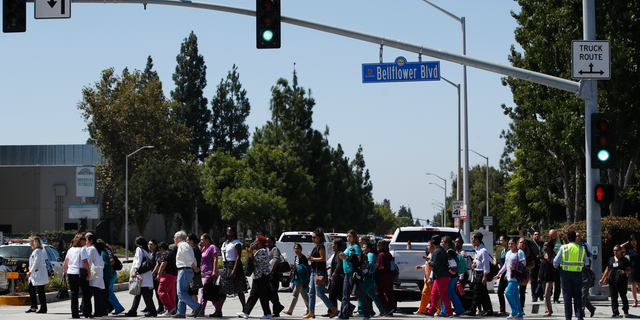 People are escorted out of Kaiser Permanente Downey Medical Center, following reports of someone with a weapon at the facility in Downey, Calif., Tuesday, Sept. 11, 2018. Authorities said an armed man who hurled a chair through a window at the facility was taken into custody and a handgun was recovered, but there’s no evidence that he fired any shots. (AP Photo/Jae C. Hong)