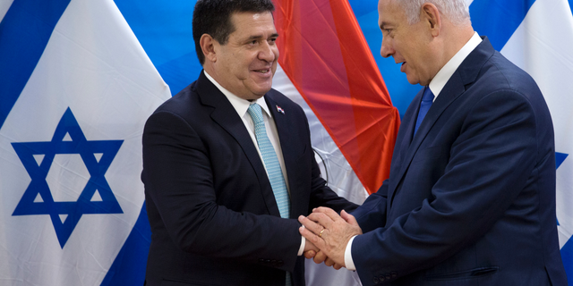 FILE - In this May 21, 2018 file photo, Israeli Prime Minister Benjamin Netanyahu, right, speaks with Paraguay's President Horacio Cartes during their meeting at the Prime Minister's office in Jerusalem. Paraguay’s government says it’s moving its embassy in Israel out of Jerusalem and back to Tel Aviv, less than four months after opening the new mission, Foreign Minister Luis Alberto Castiglioni announced Wednesday, Sept. 5, 2018. (AP Photo/Sebastian Scheiner, Pool, File)