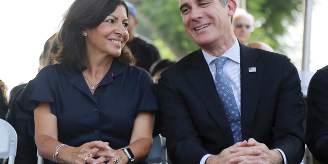 Paris Mayor Anne Hidalgo and Los Angeles Mayor Eric Garcetti speaks during a ceremony marking the 17th anniversary of the Sept. 11, 2001 terrorist attacks on America, at the Los Angeles Fire Department's training center Tuesday, Sept. 11, 2018. The mayors of Paris and Los Angeles met Tuesday ahead of a global climate summit to memorialize the victims of the 9/11 attacks on the U.S., and to talk about the commonalities between the two cities amid an increasingly divided world. The mayors then helped pack lunches for the needy. (AP Photo/Reed Saxon)