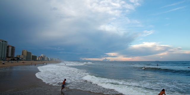 Surfers head to the waves, Tuesday, Sept. 11, 2018, in Virginia Beach, Va., before the arrival of Hurricane Florence. (AP Photo/Alex Brandon)