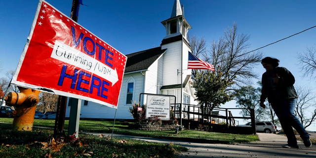 FILE - In this Tuesday, Nov. 8, 2016 file photo, a local resident leaves a church after voting in the general election in Cumming, Iowa. Religion's role in politics and social policies is in the spotlight heading toward the midterm elections, yet relatively few Americans consider it crucial that a candidate be devoutly religious or share their religious beliefs, according to an AP-NORC national poll conducted Aug. 16-20, 2018. (AP Photo/Charlie Neibergall)