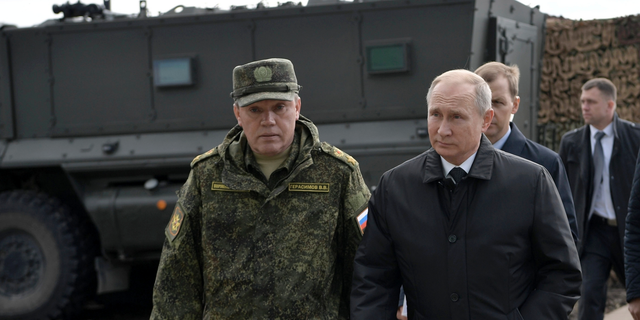 Russian President Vladimir Putin, right, and Head of the General Staff of the Armed Forces of Russia and First Deputy Defense Minister Valery Gerasimov arrive to attend military exercises about 80 kilometers (50 miles) north of the city of Chita during the military exercises Vostok 2018 in Eastern Siberia, Russia, Sept. 13, 2018. 