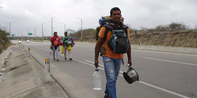 Venezuelan Omar Mujica, a car mechanic, walks to Lima, along the shoulder of the Pan-American Highway, as other Venezuelan migrants follow, after crossing the border from Ecuador into Peru, near Tumbes, Peru, Sunday, Aug. 26, 2018. Mujica, from Barquisimeto, said his car broke down before he started his trip, two weeks ago, and left it behind, unable to sell it. The U.N. estimates 2.3 million Venezuelans have fled since 2014 as the country with the world's largest proven oil reserves plummets into an economic crisis worse than the Great Depression. (AP Photo/Martin Mejia)