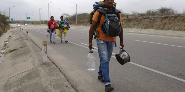Venezuelan Omar Mujica, a car mechanic, walks to Lima, along the shoulder of the Pan-American Highway, as other Venezuelan migrants follow, after crossing the border from Ecuador into Peru, near Tumbes, Peru, Sunday, Aug. 26, 2018. Mujica, from Barquisimeto, said his car broke down before he started his trip, two weeks ago, and left it behind, unable to sell it. The U.N. estimates 2.3 million Venezuelans have fled since 2014 as the country with the world's largest proven oil reserves plummets into an economic crisis worse than the Great Depression. (AP Photo/Martin Mejia)
