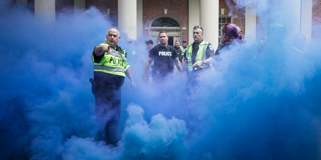 Police deploy smoke bombs into a crowd to disperse protesters after making arrests on the campus of the University of North Carolina campus in Chapel Hill, N.C., on Saturday, Sept. 8, 2018. Supporters and opponents of the Silent Sam statue faced off again late Saturday afternoon on the UNC campus, yelling at each other at the base where the Confederate monument was toppled last month. (Julia Wall/The News &amp; Observer via AP)