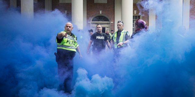 Police deploy smoke bombs into a crowd to disperse protesters after making arrests on the campus of the University of North Carolina campus in Chapel Hill, N.C., on Saturday, Sept. 8, 2018. Supporters and opponents of the Silent Sam statue faced off again late Saturday afternoon on the UNC campus, yelling at each other at the base where the Confederate monument was toppled last month. (Julia Wall/The News & Observer via AP)
