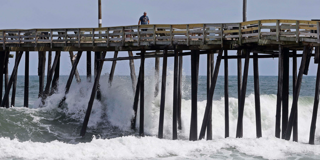 Waves crash under a pier in Kill Devil Hills, N.C., Wednesday, Sept. 12, 2018, as Hurricane Florence approaches the east coast. (AP Photo/Gerry Broome)