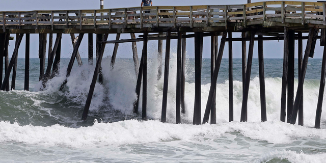 Waves crash under a pier in Kill Devil Hills, N.C., Wednesday, Sept. 12, 2018, as Hurricane Florence approaches the east coast. (AP Photo/Gerry Broome)