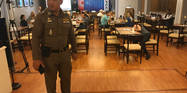 In this Thursday, Sept. 6, 2018, photo, a Thai policeman stands inside Foreign Correspondents' Club of Thailand during an event titled: "Will Myanmar's General Ever Face Justice for International Crimes" in Bangkok, Thailand. Police shut down a forum organized by foreign journalists to discuss whether senior military officers in Myanmar should face justice for alleged human rights abuses committed by their forces against Rohingya Muslims and other ethnic minorities. (AP Photo/Tassanee Vejpongsa)