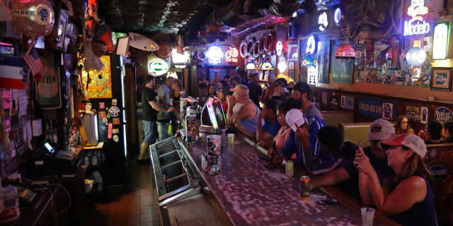 Locals have a drink as they relax at the Barbary Coast bar in downtown Wilmington, N.C., as Florence threatens the coast Thursday, Sept. 13, 2018. (AP Photo/Chuck Burton)