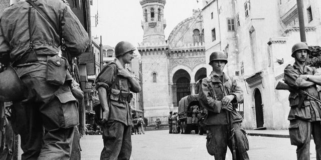 FILE - In this May 27, 1956 file photo, French troops seal off Algiers' notorious casbah, 400-year-old teeming Arab quarter. French President Emmanuel Macron has formally recognized that the French state was responsible for the death of a dissident mathematician in Algeria in 1957, admitting for the first time the French military's "system" of torture during Algeria's independence war. (AP Photo)
