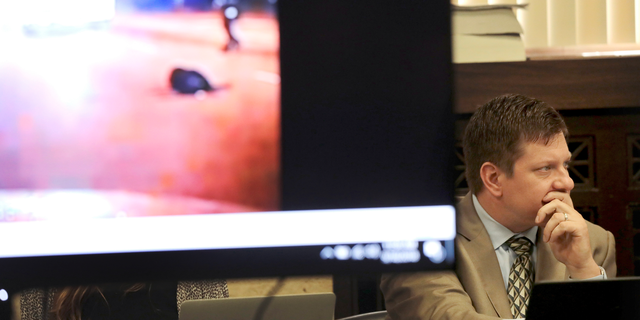 Chicago police Officer Jason Van Dyke listens at right during the second day of his murder trial for the 2014 killing of Laquan McDonald on Tuesday, Sept. 18, 2018, as a video image of McDonald body lying in the street is displayed in court at the Leighton Criminal Court Building in Chicago. (Antonio Perez/Chicago Tribune via AP, Pool)