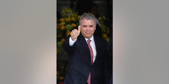 Colombia's President Ivan Duque gives a thumps up to the press during a welcoming ceremony for him at the presidential palace in Panama City, Monday, Sept. 10, 2018. Duque is in Panama on a one-day official visit. (AP Photo/Arnulfo Franco)
