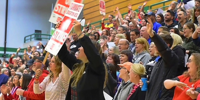 Meeting in the Tumwater High School gymnasium Monday, Sept. 17, 2018, in Tumwater, Wash. Black Hills High School teacher Matt Bell leads a jubilant group of his fellow educators in the Neil Diamond song "Sweet Caroline" as they celebrate a 98% ratification of their new two-year contract with the district. (Steve Bloom/The Olympian via AP)