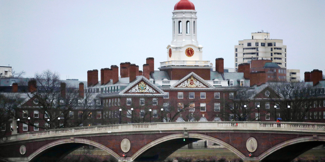 In this March 7, 2017 file photo, rowers paddle along the Charles River past the Harvard College campus in Cambridge, Mass.