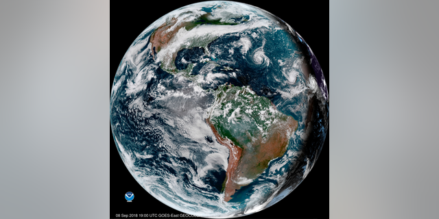 This enhanced satellite image made available by NOAA shows Tropical Storm Florence, third from right, in the Atlantic Ocean on Saturday, Sept. 8, 2018 at 3 p.m. EDT. At right, off the coast of Africa is Tropical Storm Helene, and second from right is Tropical Depression 9. (NOAA via AP)