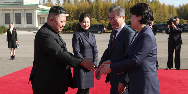North Korean leader Kim Jong Un, left, flanked by his wife Ri Sol Ju, second from left, bids farewell to South Korean President Moon Jae-in, second from right, and his wife Kim Jung-sook, at Samjiyon airport, in North Korea, Thursday, Sept. 20, 2018. A beaming South Korean President Moon, freshly returned home Thursday from a whirlwind three-day summit with Kim Jong Un, said the North Korean leader wants the U.S. secretary of state to visit Pyongyang soon for nuclear talks, and also hopes for a quick follow-up to his June summit with President Donald Trump. (Pyongyang Press Corps Pool via AP)