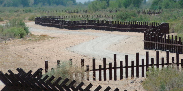 This June 15, 2017, photo provided by Kenneth Madsen, shows a post-on-rail style of fence along the flood plain of the Colorado River between Arizona and Baja California, which is typical of border wall fences placed in environmentally sensitive areas or in areas prone to flooding. A new photo exhibit by Madsen opening Wednesday, Sept. 19, 2018, at the Ohio State University-Newark campus, "Up Close with U.S.-Mexico Border Barriers,” highlights different types of border wall fencing. (Kenneth Madsen via AP)