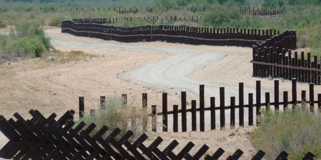 This June 15, 2017, photo provided by Kenneth Madsen, shows a post-on-rail style of fence along the flood plain of the Colorado River between Arizona and Baja California, which is typical of border wall fences placed in environmentally sensitive areas or in areas prone to flooding. A new photo exhibit by Madsen opening Wednesday, Sept. 19, 2018, at the Ohio State University-Newark campus, "Up Close with U.S.-Mexico Border Barriers,” highlights different types of border wall fencing. (Kenneth Madsen via AP)