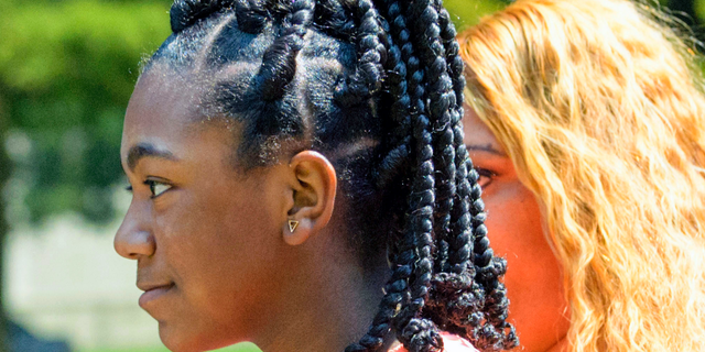 FILE - In this Friday, Aug. 24, 2018, file photo, Faith Fennidy walks to a news conference outside the offices of attorney James Williams, in Metairie, La. Parents of two New Orleans-area school girls have dismissed their lawsuit against a Catholic school, Monday, Sept. 10, over its policy forbidding hair extensions. Christ the King school rescinded the policy late last month amid accusations that it was discriminatory against black students. The school and the Archdiocese of New Orleans drew widespread online outrage after video spread of Fennidy tearfully leaving school after being told her hair style violated the policy. (Matthew Hinton/The Advocate via AP, File) /The Advocate via AP)