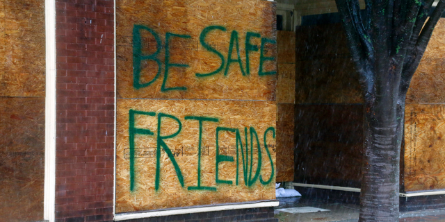 A message on a boarded-up business encourages people to be safe as Hurricane Florence hits downtown New Bern, N.C., on Friday, Sept. 14, 2018. (AP Photo/Chris Seward)