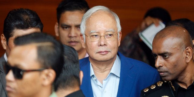 In this May 22, 2018, file photo, former Malaysian Prime Minister Najib Razak, center, arrives at Anti-Corruption Agency for questioning in Putrajaya, Malaysia. Malaysia's anti-graft agency says it has arrested former Najib over the multimillion-dollar looting of a state investment fund and that he will face further charges in court.  The agency says Najib was detained at its office on Wednesday, Sept. 14, and will be taken to court on Thursday to face the charges. (AP Photo/Vincent Thian)