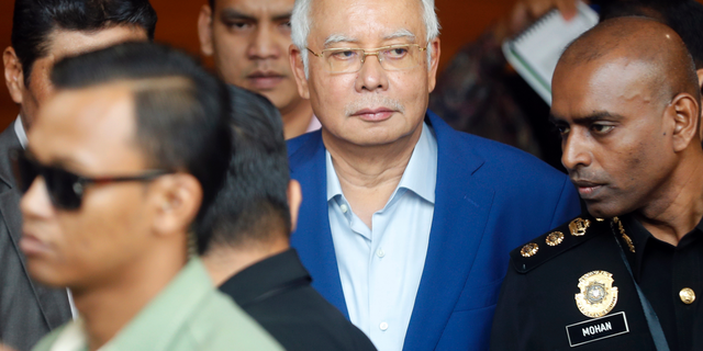 In this May 22, 2018, file photo, former Malaysian Prime Minister Najib Razak, center, arrives at Anti-Corruption Agency for questioning in Putrajaya, Malaysia. Malaysia's anti-graft agency says it has arrested former Najib over the multimillion-dollar looting of a state investment fund and that he will face further charges in court. The agency says Najib was detained at its office on Wednesday, Sept. 14, and will be taken to court on Thursday to face the charges. (AP Photo/Vincent Thian)