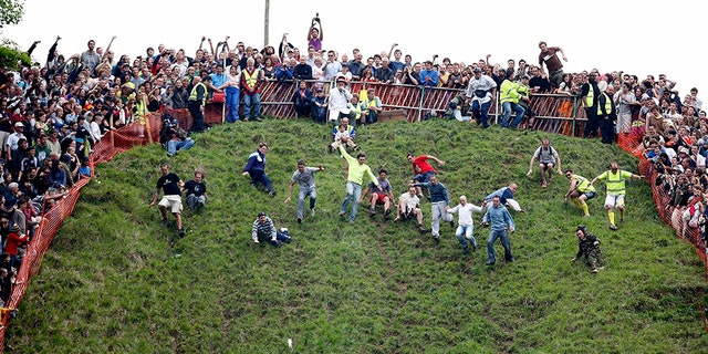 The annual Cooper’s Hill Cheese Roll in Brockworth, England, draws hundreds of spectators eager to watch people hurl themselves down the steep hill after wheels of cheese.