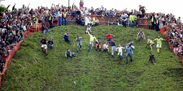 The annual Cooper’s Hill Cheese Roll in Brockworth, England, draws hundreds of spectators eager to watch people hurl themselves down the steep hill after wheels of cheese.