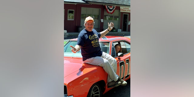 In this Aug. 10, 1999, file photo, 'Cooter,' actor Ben Jones, sits atop one of the 229 hotrods, named The General Lee, used in the show 'Dukes of Hazzard' in front of his store in Sperryville, Va.